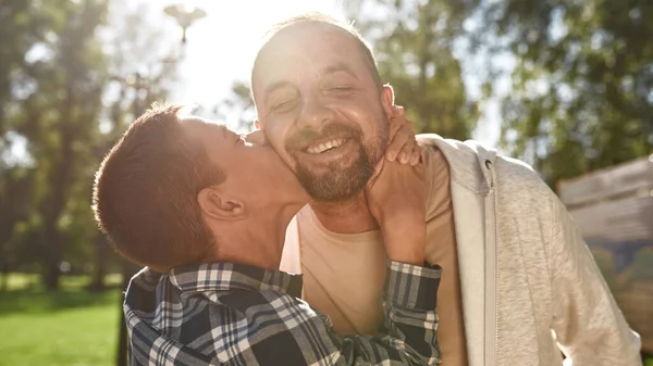 Boy with disability hug and kiss father in park — Φωτογραφία Αρχείου