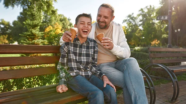 Baba yiyor ve dondurmayı besliyor.