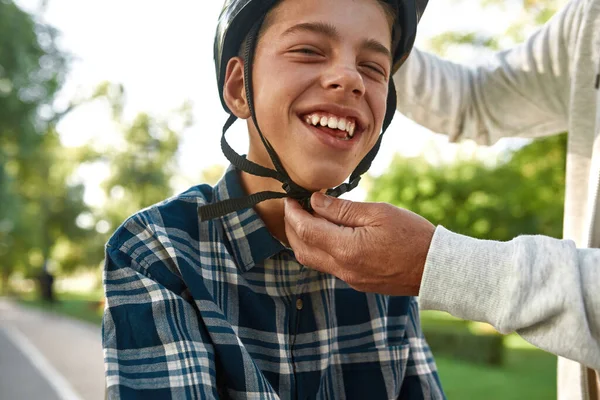 Cropped of father put bicycle helmet on son head — Foto de Stock