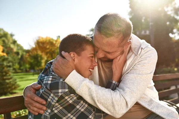 Father and joyful teenage son hugging and resting — Stockfoto