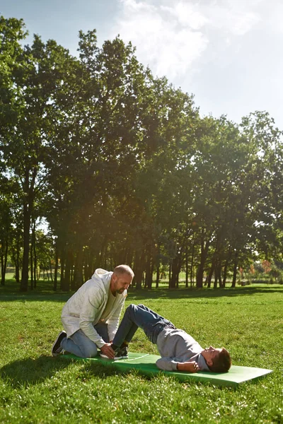Baba oğluna beyin felci egzersizinde yardım ediyor.
