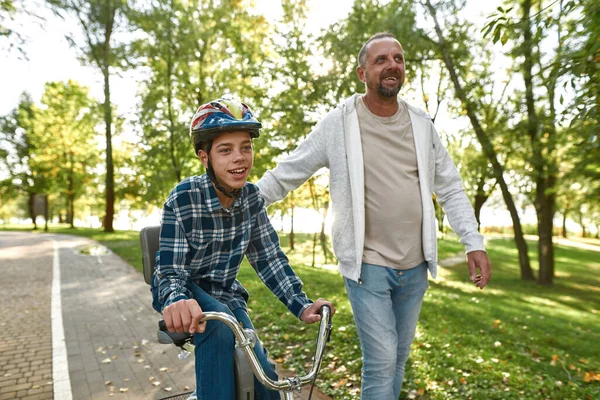 Father help son with cerebral palsy ride bicycle —  Fotos de Stock