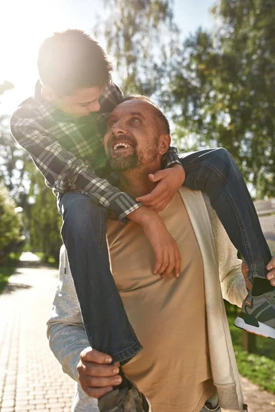 Happy caucasian dad carry on shoulders teenage son — Stok fotoğraf