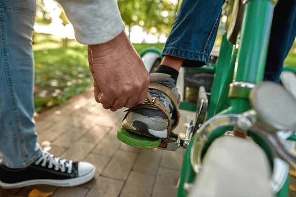 Father fasten belt of bicycle to leg of his son — Foto de Stock