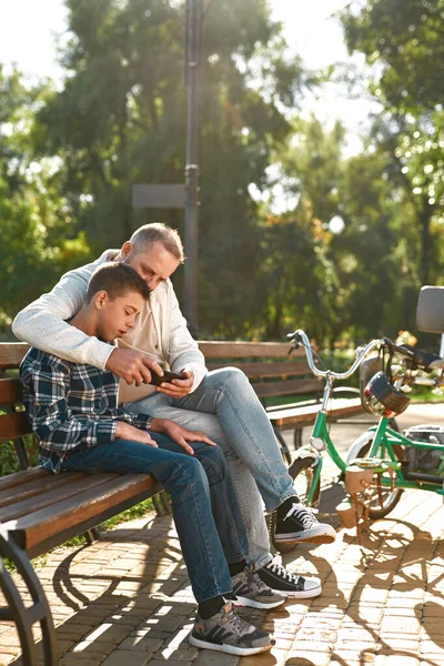 Тато і син з церебральним паралічем дивляться мобільний телефон. — стокове фото