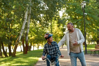 Engelli bir baba ve oğlu parkta dinleniyor.