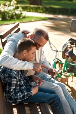 Babası oğlunun dijital tabletini işaret ediyor.