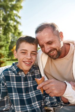 Baba dondurma oğlunu parkta beyin felciyle besliyor.
