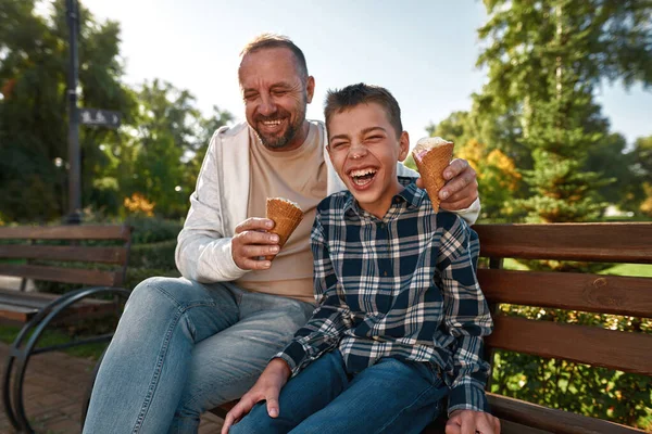 Father eat and feed ice cream cheerful teenage son — Stok fotoğraf