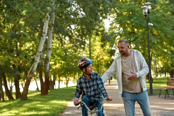 Engelli bir baba ve oğlu parkta dinleniyor.