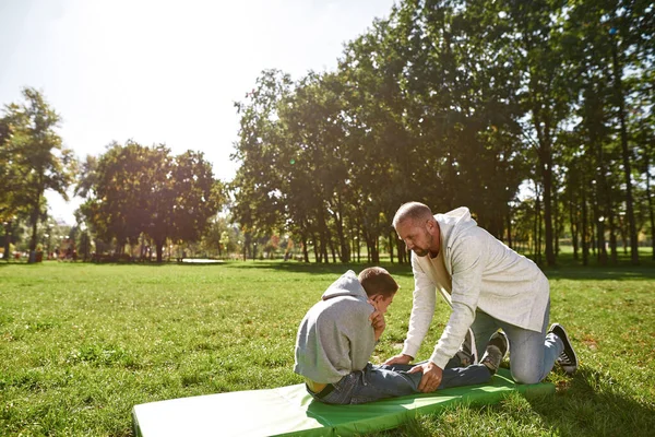 Father helping son with cerebral palsy crunching — Foto de Stock
