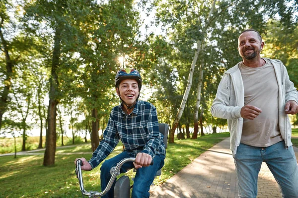 Father jog while son with disability ride bicycle — Foto de Stock