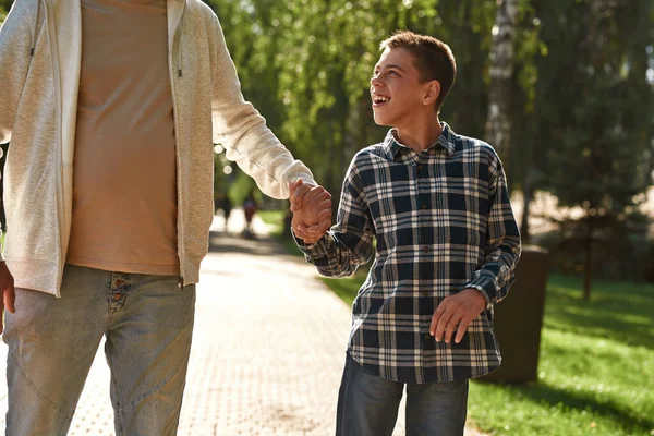 Father and son holding hands and walking in park — Stok fotoğraf