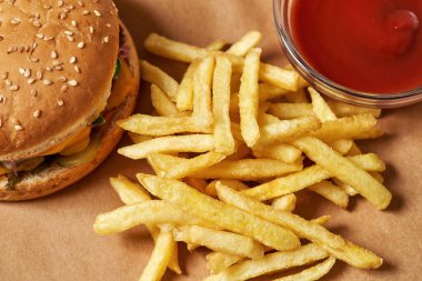 Burger, french fries and sauce on recyclable paper