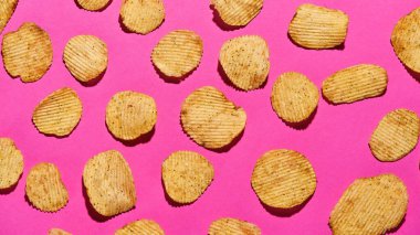 Pembe arka planda lezzetli patates cipsleri