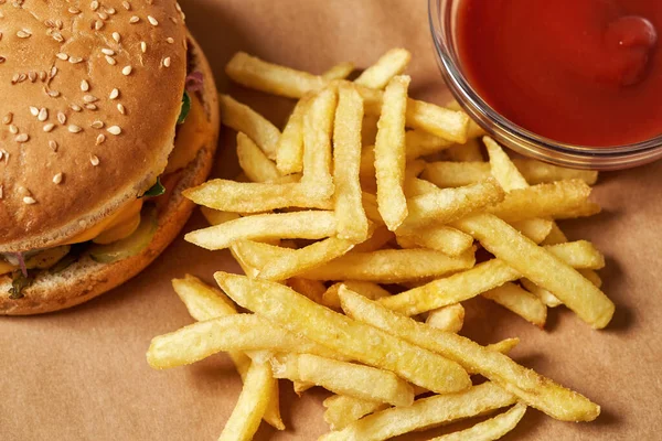 Burger, french fries and sauce on recyclable paper
