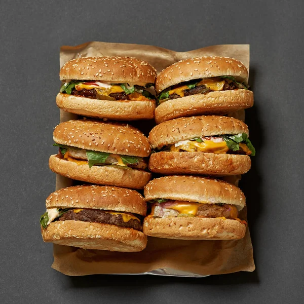 Hambúrgueres apetitosos clássicos em papel artesanal na bandeja — Fotografia de Stock