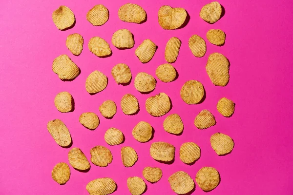 Set chips in rijen geïsoleerd op roze achtergrond — Stockfoto