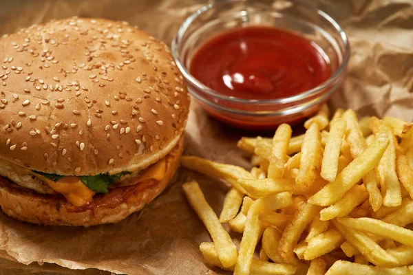 Klasik burger, patates kızartması ve sos.