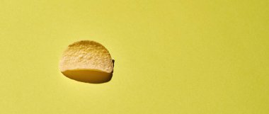 Sarı arka planda izole edilmiş lezzetli patates cipsi.