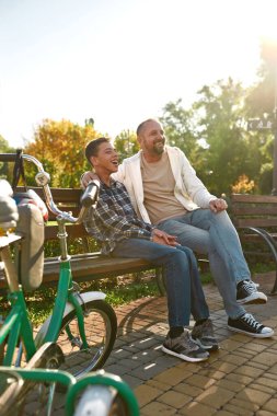 Dad and teenage son with cerebral palsy on bench