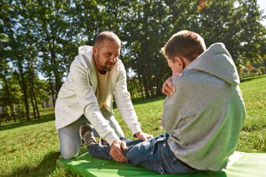 Baba engelli oğluna yardım et. Spor paspası üzerinde çıtır çıtır.