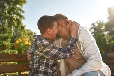 Serebral felçli baba ve gülümseyen oğul sarılıyor.