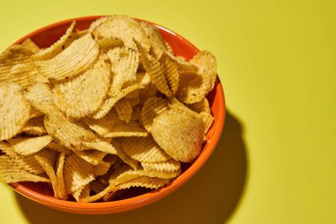 Bir kase dolusu iştah açıcı patates cipsi yakın.