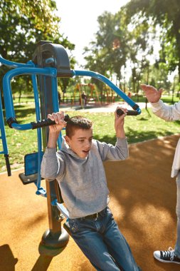 Serebral felçli çocuk babasının yanında egzersiz yapıyor.