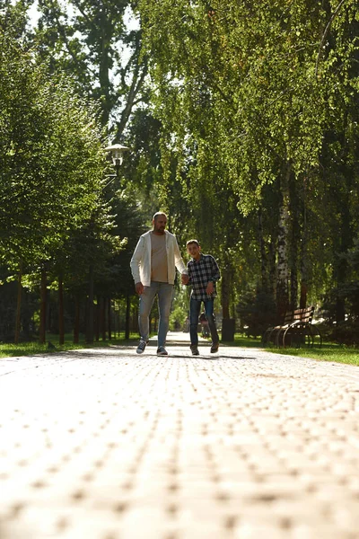 Bottom view of father and son walking on pavement — Foto de Stock