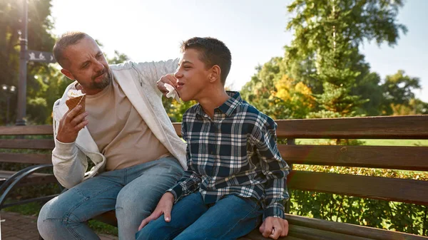 Father wiping face of son with cerebral palsy