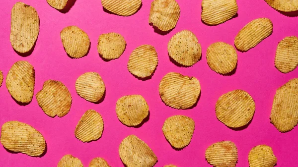 Isolated pink backdrop of appetizing potato chips — Zdjęcie stockowe