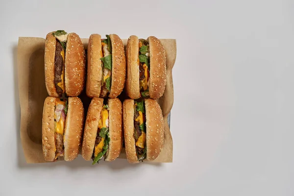 Vista superior de seis hambúrgueres em papel artesanal em bandeja — Fotografia de Stock