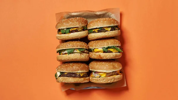 Top de deliciosos hambúrgueres em papel artesanal na bandeja — Fotografia de Stock