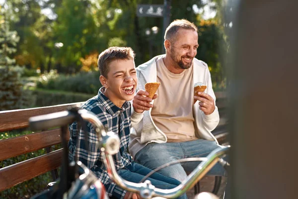 Laughing father feed tasty ice cream teenage son — Foto de Stock