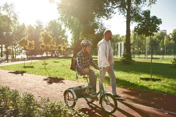 Baba engelli bisikletli oğlunun yanına git.