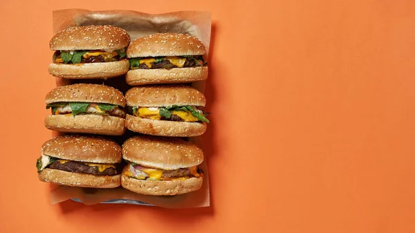 Top view of fresh burgers on craft paper in tray — Stok fotoğraf