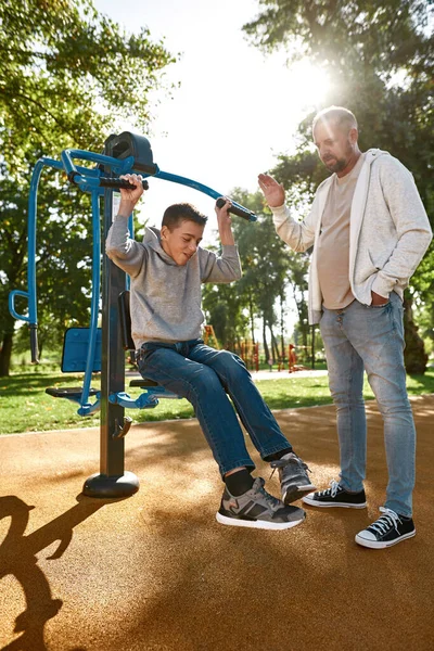 Pappa hjälpa son med funktionshinder motion axlar — Stockfoto