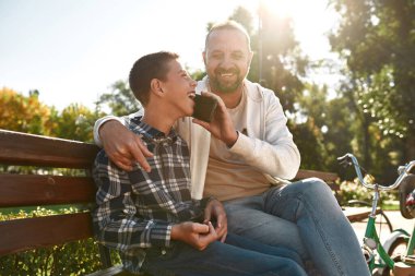 Father help son with disability talk on smartphone
