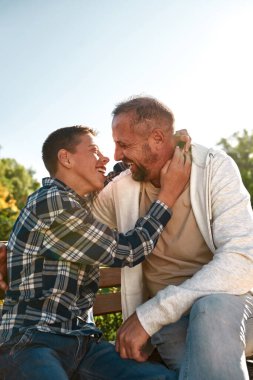 Side view of dad and son with cerebral palsy hug