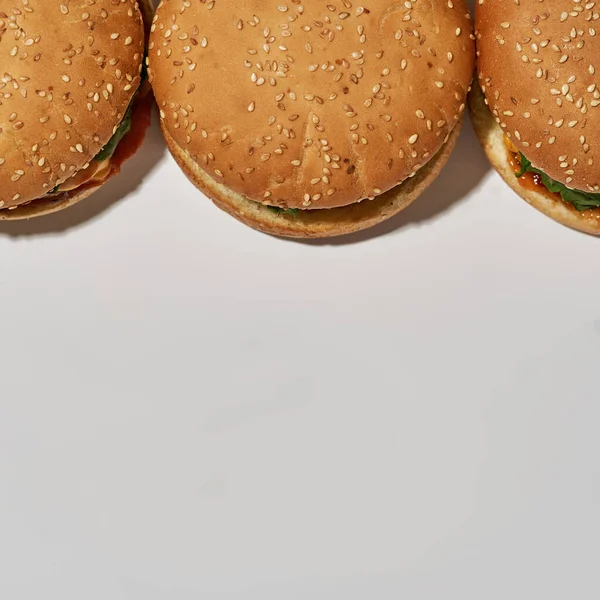 Tasty burgers on white background with copy space