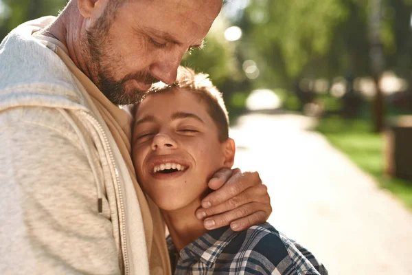 Baba parkta beyin felci geçiren mutlu oğluna sarıldı. — Stok fotoğraf