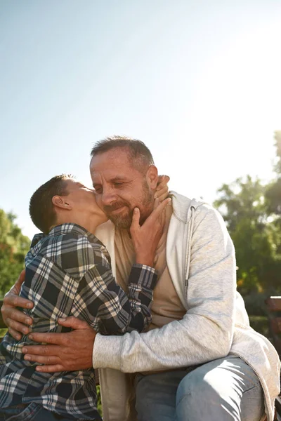 Boy with cerebral palsy kissing his happy father — ストック写真