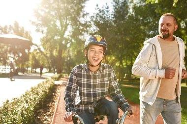 Serebral felçli bisikletli bir adam ve bir çocuk.