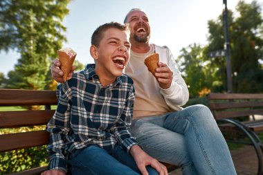 Engelli baba ve oğlu dışarıda dondurma yiyorlar.