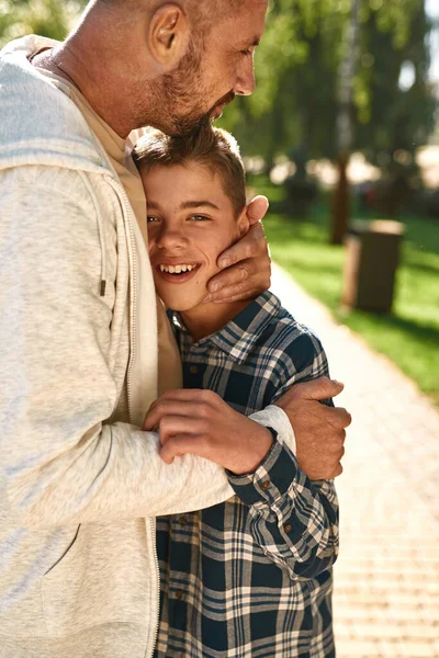 Baba, beyin felci geçiren neşeli genç oğlanı kucaklıyor. — Stok fotoğraf