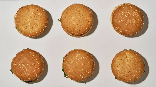 Vista superior de seis hambúrgueres saborosos clássicos em fileiras — Fotografia de Stock
