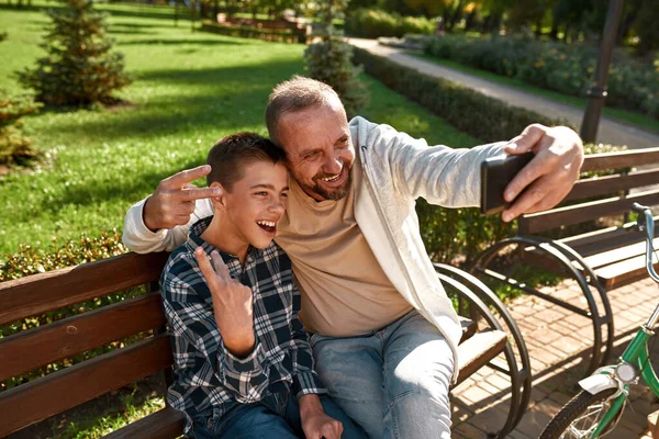 Dad and boy show victory sign during take selfie — Stok fotoğraf