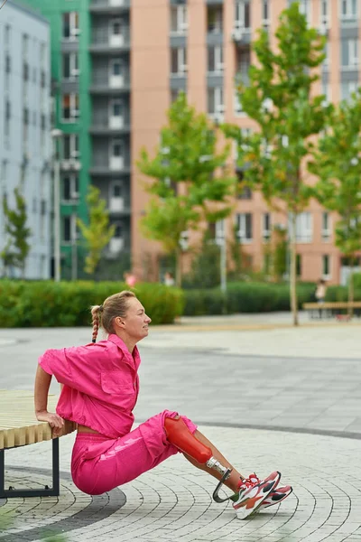 Girl has disability do exercise on bench in city — Stock Photo, Image