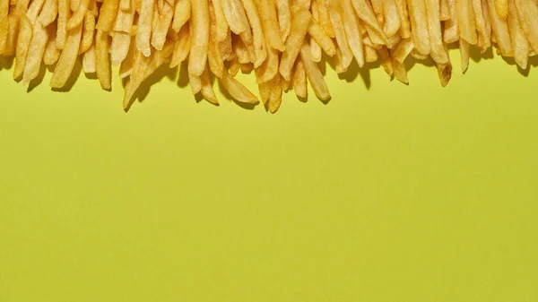 Heerlijke frietjes op rij op gele achtergrond — Stockfoto